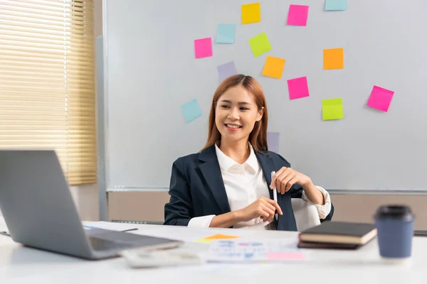 stock image Concept of modern girl leadership, Businesswoman holding pen and looking business data on laptop.