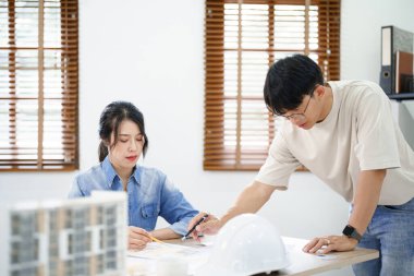 Mühendislik danışmanlığı kavramı, erkek mühendis, bina planlarını meslektaşlarına açıklıyor..