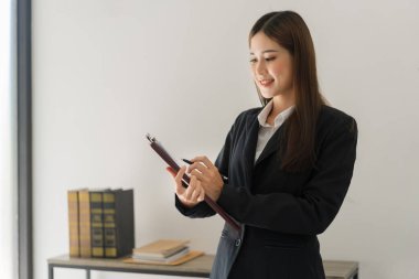 Hukuk ve adalet kavramı, kadın avukat yönetmeliğe ilişkin sözleşmeyi okuyor ve hukuk firmasında çalışıyor..