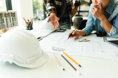 Ofisteki inşaat projesinin planını tartışmak ve beyin fırtınası yapmak için çalışan iki mühendis..