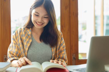 Eğitim ve okur yazarlık kavramı, üniversiteli kız üniversite kütüphanesinde kitap okuyor..