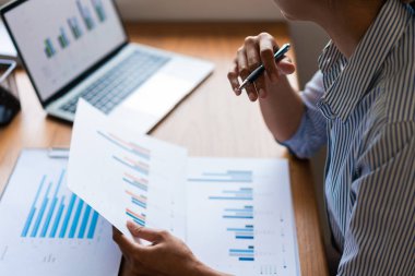 İş kadınına yakın plan, dizüstü bilgisayar ve iş belgesinde veri okurken strateji düşünüyor.