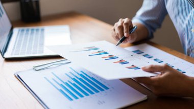 İş adamının eli kulağında mali belge ve iş stratejisi analizi yapılıyor.