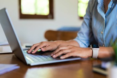 Ofisteki masada çalışırken dizüstü bilgisayarda veri yazan iş kadınının ellerini kapat..
