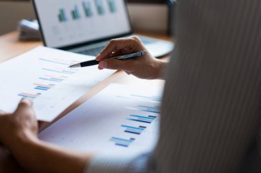 İş adamının eli kulağında mali belge ve iş stratejisi analizi yapılıyor.