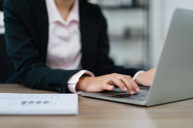 Yeni başlangıç projesinin pazarlama planını planlayan ve dizüstü bilgisayarda finans verileri yazan iş kadını.