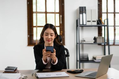 İş kadını akıllı telefondan sohbete ve pazarlama planı planlamasına mesaj yazıyor.