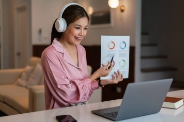 İş kadını, iç işlerinde video görüşmesi sırasında ortaklarıyla mali belgeyi açıklıyor.