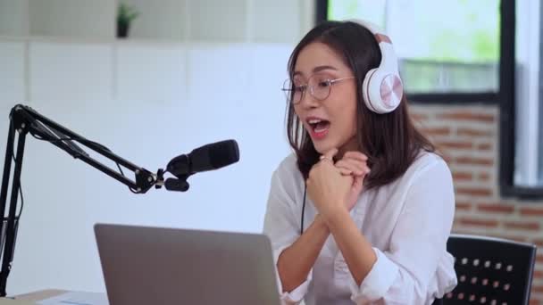 年轻的亚洲妇女主持人或Dj向订户播放音频播客或制作音频 使用麦克风和戴耳机 — 图库视频影像