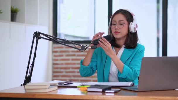 若いアジアの女性のプレゼンターやDjは オーディオポッドキャストを購読するか オーディオを作る マイクを使用して ヘッドフォンを身に着けている — ストック動画