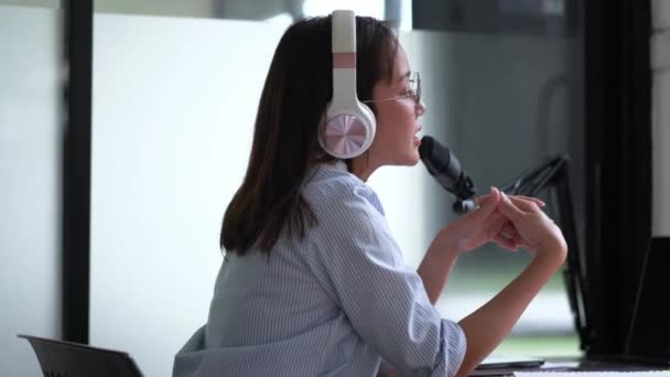 年轻的亚洲妇女主持人或Dj向订户播放音频播客或制作音频 使用麦克风和戴耳机 — 图库视频影像