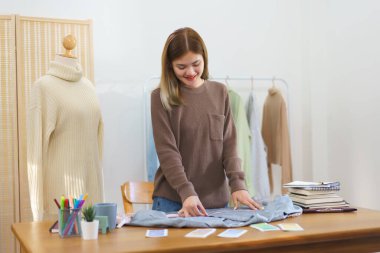 Moda tasarımı konsepti, moda tasarımcısı müşteri göndermeden önce kontrol edilecek gömleğin boyutunu ölçüyor.