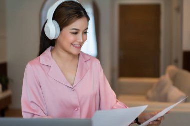 İş kadını, merkez büroda iş ortaklarıyla görüşürken mali belgeleri okuyor.