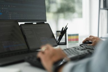 Web ve uygulamaları geliştirmeye programlama sırasında çoklu monitörde kodları kontrol eden geliştirici.