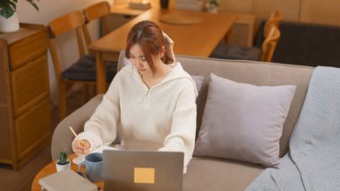 Kış mevsimi konsepti, dizüstü bilgisayarda çalışan ve gece geç saatlerde not defterine veri yazan genç bir kadın..