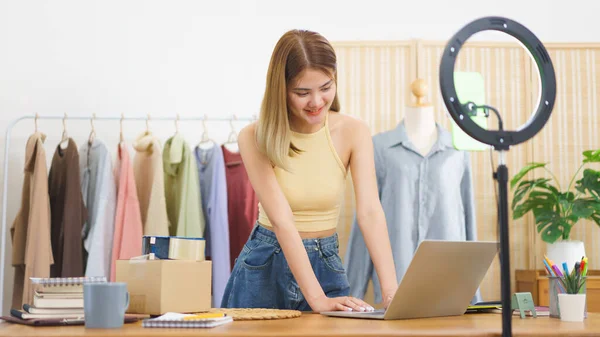 Online merchant concept, Fashion designer checks online cloth shopping order and working on laptop.