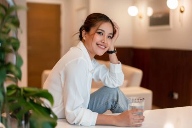 Kadın girişimci, iç işlerinde çalıştıktan sonra dinlenirken içme suyu içiyor..