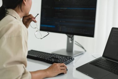 Geliştirici programcı web ve uygulama geliştirme programlama sırasında monitörde kodu kontrol ediyor.