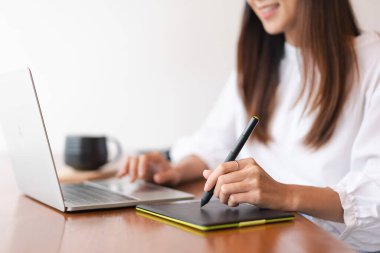 İş kadınları yeni açılan dizüstü bilgisayarın finansman verilerini stilus kalem ve analiziyle dijital tablet kullanırlar.