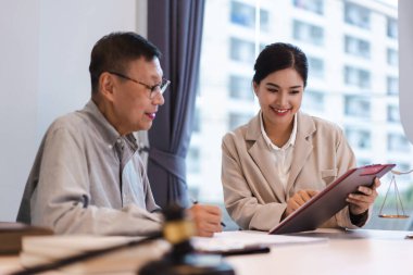Kadın avukat, üst düzey iş adamlarına yasal anlaşmayla sözleşme şartlarını tartışıyor ve açıklıyor..