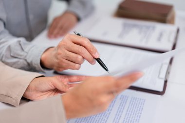 Kıdemli işadamı, kadın avukatla olan dönem ve yasal anlaşmanın sorulduğu sözleşmeye işaret ediyor.