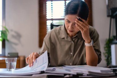 Gündelik iş kadınları ofiste finans gazetelerini okurken ve kontrol ederken stres ve baş ağrısı.