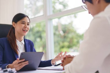 Avukat kadın, iş sözleşmesi ve iş adamıyla yapılan hukuki anlaşma hakkında tablet kullanıyor..