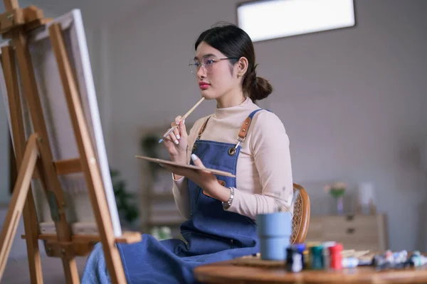 Fiatal Ázsiai Női Művész Tart Ecsetet Miközben Nézett Vásznon Gondolkodni — Stock Fotó