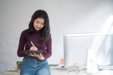 Grafik tasarımcısı serbest kadınlar yaratıcı fikirleri düşünerek ve logo markası çizmek için dijital tablet kullanarak ev stüdyosunda teknolojik ekipmanlarla grafik tasarımı hakkında çalışırken.