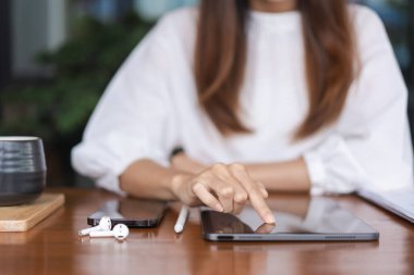 İş kadınları veri araştırırken ve tablet üzerinde finans verileri okurken, yeni kuruluş hakkında analiz yaparken.