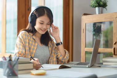 Education and literacy concept, College student girl listening lecture online and doing test.