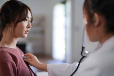 Asyalı psikolog kadınlar hastaları kontrol etmek için steteskop kullanırken ve ilaç ve zihinsel sağlık terapisi hakkında danışmanlık yaparken, kadın hastalar psikolojik sağlık sorunu ve strese maruz kalıyor..