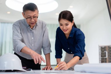 İki mimar inşaat projesini tartışmak ve planlamak için planı işaret ediyor.