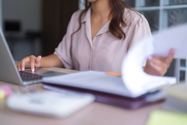 Gündelik giysiler içindeki Asyalı genç öğrenci eğitim belgesini okuyor ve öğretim görevlilerinin online eğitimini öğrenirken özel ders izliyor ve üniversitede dizüstü bilgisayarlı dijital teknolojiyle ödev yapıyor..