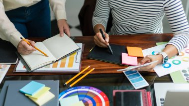 İki yaratıcı grafik tasarımcısı proje tasarlamak ve tartışmak için renk örnekleri bulundurur..