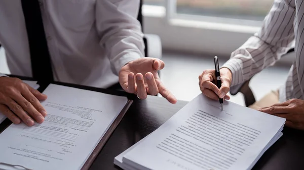 Businessman real estate seller discussion to explaining about property investment document with terms data of home sales contract and home insurance while businesswoman signing signature on contract.