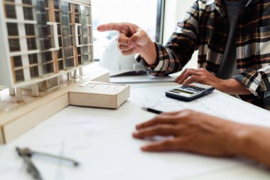 Ofisteki inşaat projesinin kondominyum modeli hakkında iki mühendis tartışması ve beyin fırtınası.