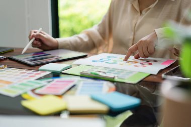 Proje tasarımı için tablet ve belge üzerindeki renk örnekleri hakkında çalışan yaratıcı grafik tasarımcısı.