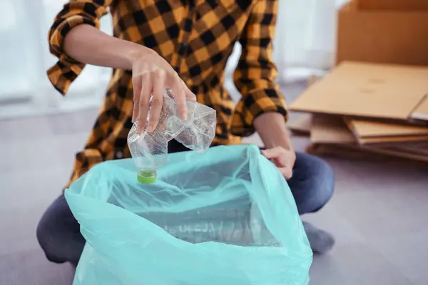Women squeeze plastic bottle and putting in plastic bag for recycling and conservation environment.