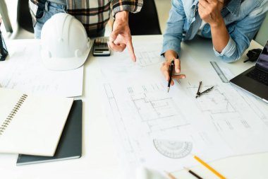 Ofisteki inşaat projesinin planlarını tartışmak ve işbirliği yapmak için çalışan iki mühendis..