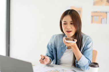 İnşaat planı konsepti, ev planı çizilirken akıllı telefondan kadın mimar konuşması.