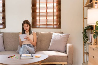 Yaratıcı tasarım konsepti, moda tasarımcısı koltukta yeni elbise koleksiyonu çizimi..