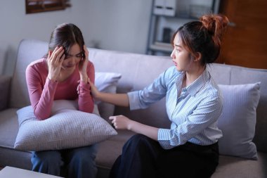 Asyalı psikolog kadınlar hastaları teşvik etmek ve ilaç ve ruh sağlığı terapisi hakkında danışmanlık yaparken, kadın hastalar psikolojik sağlık sorunları ve baş ağrıları hakkında.