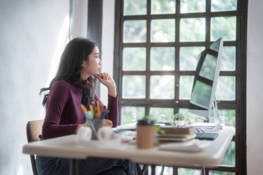 Grafik tasarımcısı serbest kadınlar yaratıcı fikirleri düşünerek ve logo markası çizmek için dijital tablet kullanarak ev stüdyosunda teknolojik ekipmanlarla grafik tasarımı hakkında çalışırken.