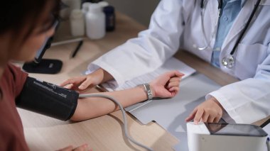 Kadın hastaların kan basıncını ve kalp atışlarını ölçmek için dijital sphygmomanometre kullanan Asyalı psikolog kadınlar klinikte tedavi ve ruhsal sağlık tedavisi hakkında danışmanlık yaparken,.