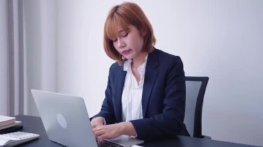 Bilgisayarında çalışan kendine güvenen Asyalı iş kadını, analitik düşünmeyi kullanarak görevlerine özenle odaklanıyor. Güçlü bir iş ahlakı ve azmi gösteriyor. Yüksek kalitede 4K görüntü.