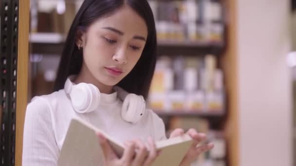 Asiatin Oder Studentin Liest Buch Auf Dem Fußboden Neben Bücherregal — Stockvideo