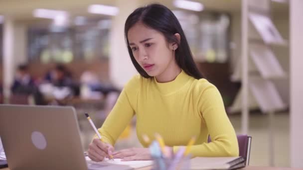 불행한 불행한 스트레스 아시아 학생은 도서관에서 도서관 책상에 시험을 고품질 — 비디오