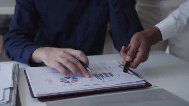 İş adamı, modern ofis ortamında özenle çalışan bir iş arkadaşıyla proje tartışıyor. Takım çalışması ve proje işbirliği gösteriliyor 