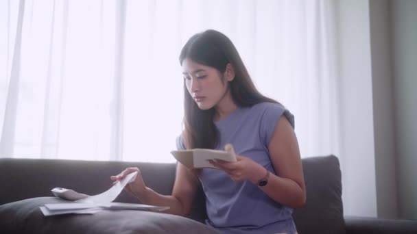 Młoda Azjatka Siedzi Sofie Używając Kalkulatora Obliczania Dochodów Wydatków Lub — Wideo stockowe